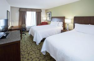 a hotel room with two beds and a television at Hilton Garden Inn Jackson/Flowood in Flowood