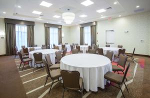 een kamer met witte tafels en stoelen en een whiteboard bij Hilton Garden Inn Jackson/Flowood in Flowood