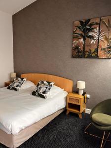 una habitación de hotel con 2 camas y una silla en Logis Le Relais Fleuri, en Sauvigny-le-Bois