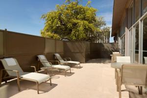 Embassy Suites by Hilton El Paso في الباسو: مجموعة من الكراسي والطاولات على الفناء