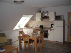 eine Küche mit einem Esstisch und eine Küche mit einem Fenster in der Unterkunft Ferienhof Mittag in Altfunnixsiel