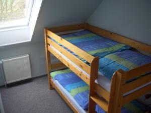 a wooden bunk bed in a room with a window at Ferienhof Mittag in Altfunnixsiel