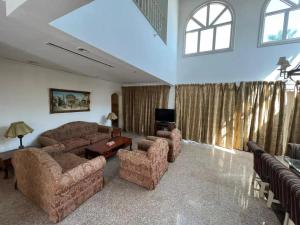 ein Wohnzimmer mit einem Sofa, Stühlen und einem TV in der Unterkunft Private villa in Sharm El Sheikh in Sharm El Sheikh