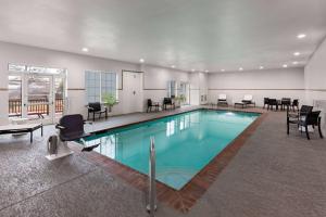 une grande piscine avec des chaises et des tables dans un bâtiment dans l'établissement La Quinta by Wyndham Austin - Cedar Park, à Cedar Park