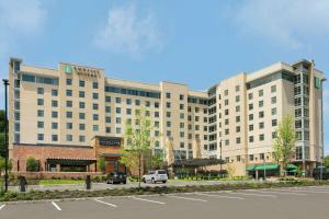 an exterior view of a hotel with a parking lot at Embassy Suites By Hilton Berkeley Heights in Berkeley Heights
