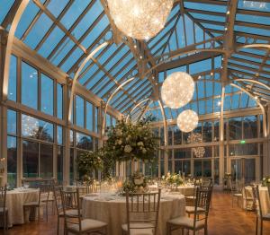 un salón de banquetes con mesas, sillas y lámparas de araña en Embassy Suites By Hilton Berkeley Heights, en Berkeley Heights