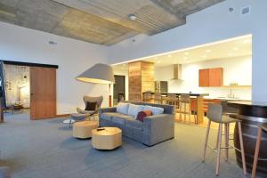 a living room with a couch and a kitchen at The Lismore Hotel Eau Claire - a DoubleTree by Hilton in Eau Claire