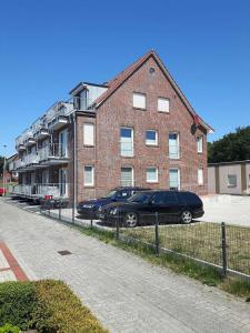 une voiture noire garée devant un bâtiment en briques dans l'établissement Ferienwohnung Claudia, à Carolinensiel