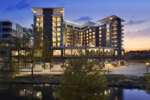 a rendering of a building with a river in front at Embassy Suites by Hilton Greenville Downtown Riverplace in Greenville