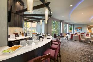 a restaurant with a breakfast bar and tables and chairs at Embassy Suites by Hilton Greenville Downtown Riverplace in Greenville