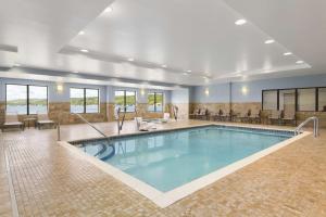 - une grande piscine dans un hôtel avec des chaises et des tables dans l'établissement Hampton Inn Penn Yan, NY, à Penn Yan