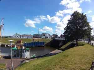 a boat is docked in a canal with houses at Pension Restaurant Zur Brücke in Carolinensiel +9 photos