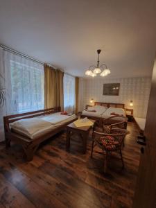 1 dormitorio con 2 camas, mesa y sillas en Hostinec Staré Hory, en Staré Hory