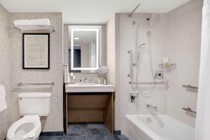 Un baño con inodoro, lavabo y bañera. en Highline Vail - a DoubleTree by Hilton, en Vail