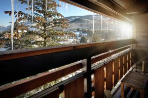 a balcony with a bench and a large window at Highline Vail - a DoubleTree by Hilton in Vail
