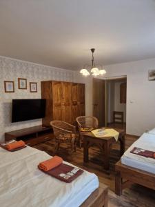 a living room with two beds and a flat screen tv at Hostinec Staré Hory in Staré Hory