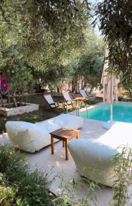 a patio with a couch and a table next to a pool at MAISON - ELEA in Ierissos