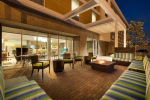 a patio with chairs and a table and a living room at Home2 Suites by Hilton Houston Energy Corridor in Houston