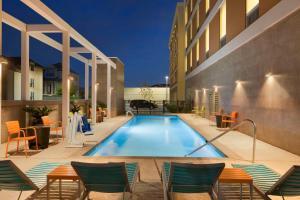 a swimming pool with chairs and a hotel at Home2 Suites by Hilton Houston Energy Corridor in Houston