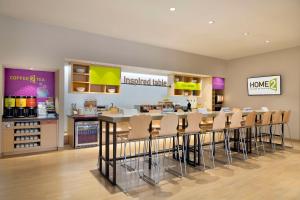 un restaurante con un bar con taburetes en una tienda en Home2 Suites by Hilton Houston Energy Corridor, en Houston