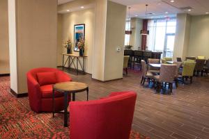 Hampton Inn & Suites Boone, Nc في بون: غرفة انتظار مع كراسي حمراء وطاولة