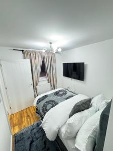 um quarto com 2 camas e uma televisão de ecrã plano em Whitehouse em Milton Keynes