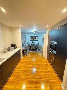 uma cozinha com pisos em madeira e uma sala de estar em Whitehouse em Milton Keynes
