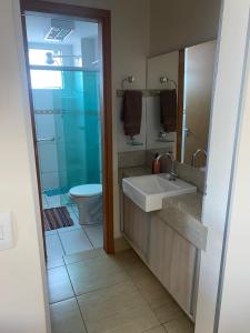 a bathroom with a sink and a toilet at Apartamento confortável em caldas novas com espaço aquático, 6 piscinas , 3 hidromassagem , Bar e Restaurante , Sauna , espaço kids in Caldas Novas