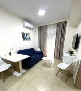 a living room with a blue couch and a table at Navarino Luxe Suites in Perea
