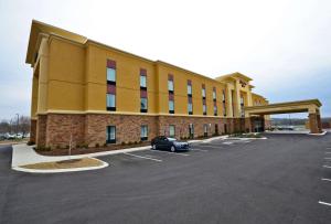 un grande edificio giallo con un'auto parcheggiata in un parcheggio di Hampton Inn Pulaski, TN a Pulaski