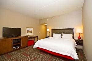 a hotel room with a bed and a flat screen tv at Hampton Inn Pulaski, TN in Pulaski