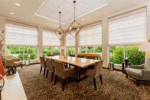 a dining room with a table and chairs and windows at Hilton Garden Inn Indiana at IUP in Indiana