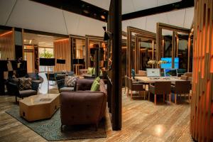 a living room with chairs and tables and mirrors at Doubletree By Hilton Iquitos in Iquitos