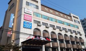 um edifício com placas na lateral em Ansan Seowon Tourist Hotel em Ansan