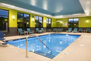 a pool in a hotel lobby with chairs and tables at Hampton Inn Westfield Indianapolis in Westfield