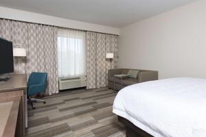 a hotel room with a bed and a desk and chair at Hampton Inn Westfield Indianapolis in Westfield