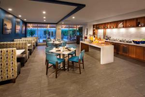 um restaurante com mesas e cadeiras e um bar em DoubleTree Resort Hollywood Beach em Hollywood