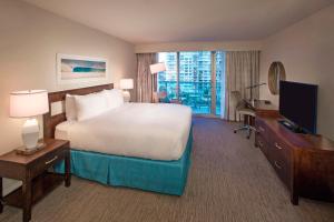 a hotel room with a large bed and a television at DoubleTree Resort Hollywood Beach in Hollywood