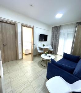a living room with a blue couch and a table at Navarino Luxe Suites in Perea