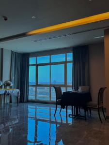 a dining room with a table and chairs and windows at MIRADOR HOTEL in Manama