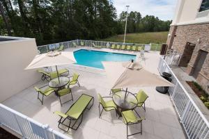 a patio with chairs and umbrellas and a pool at Hampton Inn and Suites Fayetteville, NC in Fayetteville