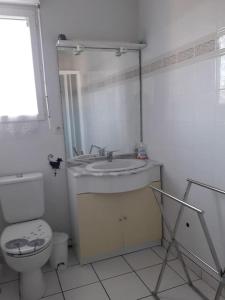 a white bathroom with a toilet and a sink at Villa quartier des Arros - 4428 in Soulac-sur-Mer