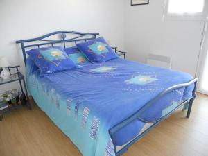 a bed with a blue comforter with dolphins on it at Villa quartier des Arros - 4428 in Soulac-sur-Mer