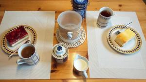 a table with cups of coffee and a piece of cake at Mühlenblick Wohnung Steuerbord Jagoda in Carolinensiel