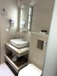 a bathroom with a sink and a toilet and a mirror at Navarino Luxe Suites in Perea
