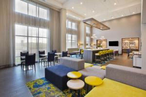 a waiting room with tables and chairs and windows at Hampton Inn & Suites By Hilton, Southwest Sioux Falls in Sioux Falls