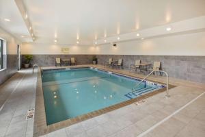 a pool in a hotel with tables and chairs at Hampton Inn & Suites By Hilton, Southwest Sioux Falls in Sioux Falls