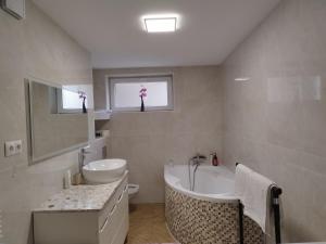 uma casa de banho com uma banheira e um lavatório e uma banheira em Piasecki Apartamenty em Lublin