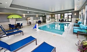 a large swimming pool with blue chairs and tables at Hampton Inn By Hilton Kirksville MO in Kirksville