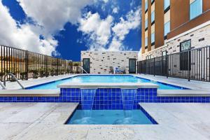 Hampton Inn & Suites Houston/Atascocita, Tx في همبل: مسبح بالبلاط الأزرق حول مبنى